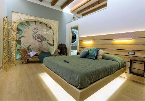卡利亚里MYO Cagliari Charming House的一间卧室设有一张大床和大墙