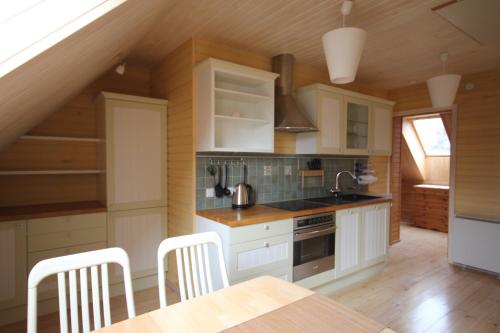 LemsiRanna puhkemaja的厨房配有白色橱柜和桌椅