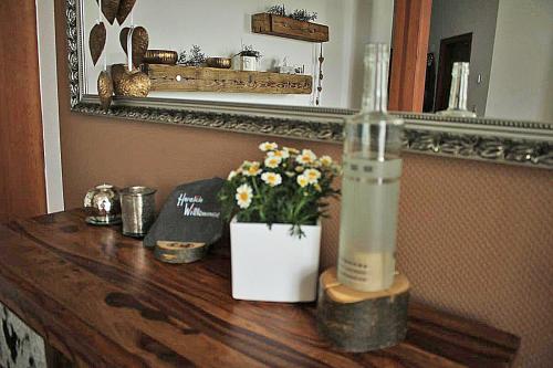 波尔Ehem. Sächsisch-Bayrischer Hof的一张木桌,上面放有一瓶和鲜花