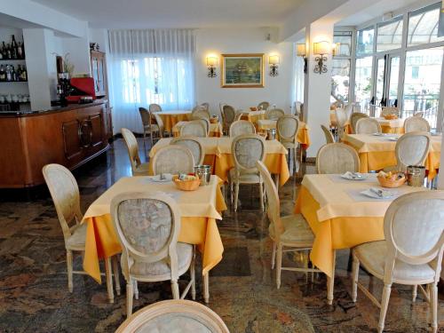 莱萨卡普里酒店的用餐室配有桌椅和黄色桌布