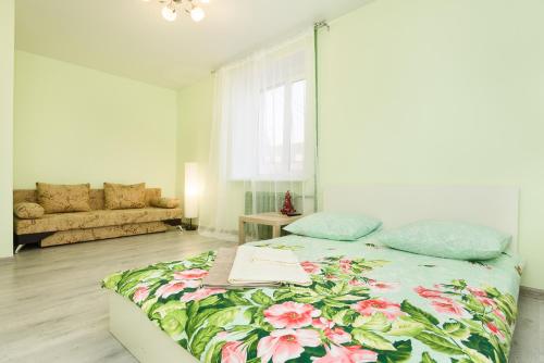 叶卡捷琳堡СелимВсех на Университетский的一间卧室配有一张带花卉图案的毯子的大床