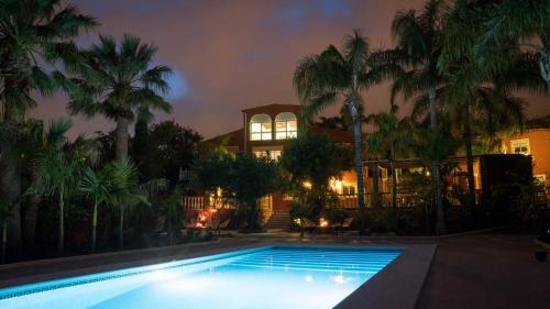贝纳尔马德纳Finca La Vida Loca - Adults Only的棕榈树屋前的游泳池