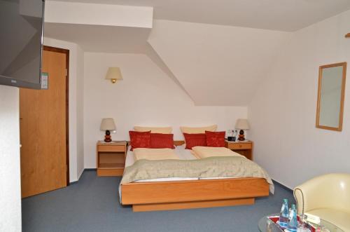 Neuferchau比克厄姆兰登翰斯酒店的一间卧室配有一张带红色枕头的大床