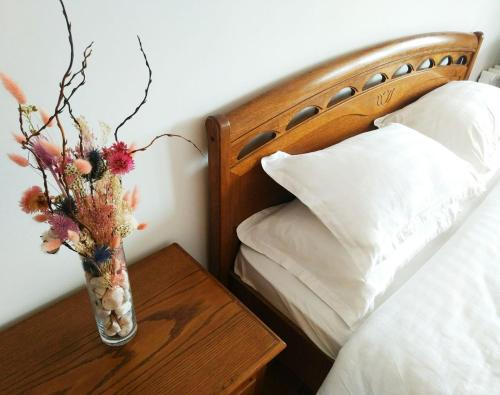 阿拉木图Loftik Apartments Abay street的花瓶,放在床边的桌子上