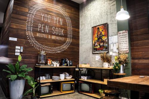 曼谷柳颜笔塾旅舍的餐厅拥有木墙,墙上有标志