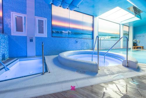 格罗韦罗拉特码头&Spa四星高级酒店的带浴缸和游泳池的大型浴室