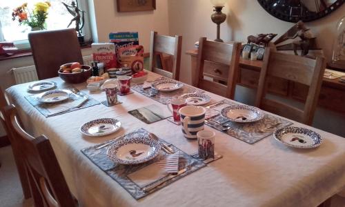 柯克宾Grovewood House Retreat的桌子上摆有盘子和餐具