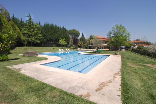 阿马里什Casa do Lago的一个带草地的庭院内的游泳池