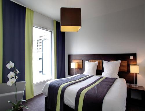 布洛涅-比扬古Lagrange Apart’Hotel Paris-Boulogne的一间卧室设有一张大床和大窗户