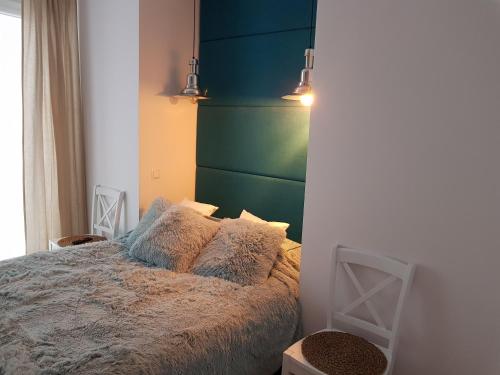 加茨比亚格拉Amko Style Apartamenty Róża Wiatrów Willa Nord的一间卧室配有一张带绿色床头板的床