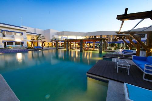 圣地亚哥米克诺斯酒店的一座带蓝色椅子的游泳池和一座建筑