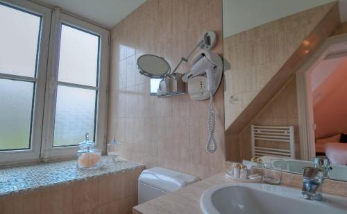 巴黎克拉尼广场酒店的一间带水槽、镜子和卫生间的浴室
