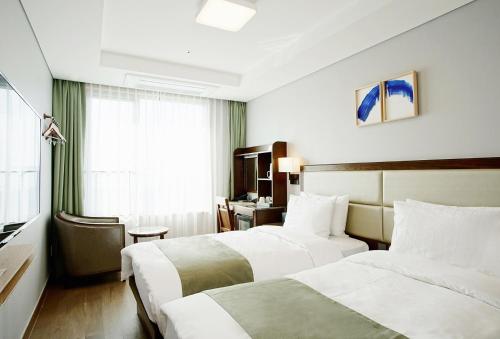 釜山Stanford Hotel Busan的酒店客房设有两张床和窗户。