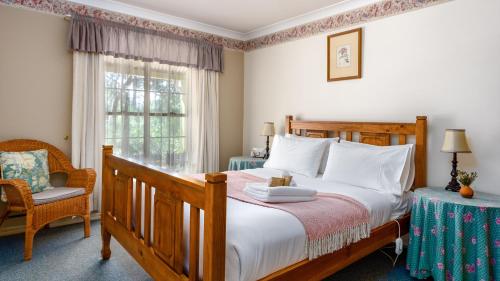 史丹霍普金银花山林小屋的卧室配有床、椅子和窗户。