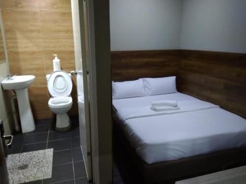 斯里巴加湾市Qing yun resthouse Bandar, Brunei Darussalam的一间小卧室,配有一张床和一个卫生间