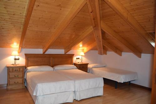 罗德里戈城太阳门旅馆的一间带两张床和木制天花板的卧室