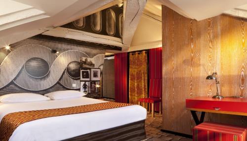 巴黎圣米歇尔圣母酒店的酒店客房,设有一张床,墙上有标志