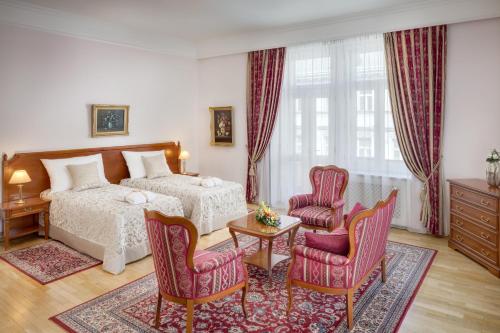 布拉格七天精品酒店的一间卧室配有一张床、两把椅子和一张桌子