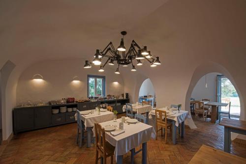 赞布热拉-杜马尔陶利尔赫达德酒店的餐厅配有白色的桌椅和吊灯