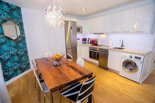 大加那利岛拉斯帕尔马斯Superb Apartament Canteras的厨房配有木桌和冰箱。