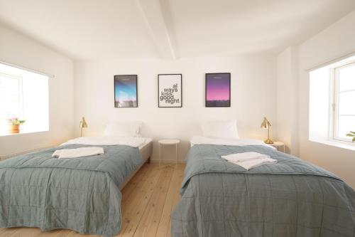 哥本哈根Rent A Place 1 - 4的配有2张床的白色墙壁和窗户客房