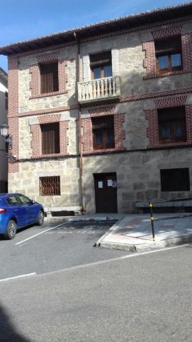 El HornilloCasa Rural del Río Tejos的停在砖楼前的蓝色汽车