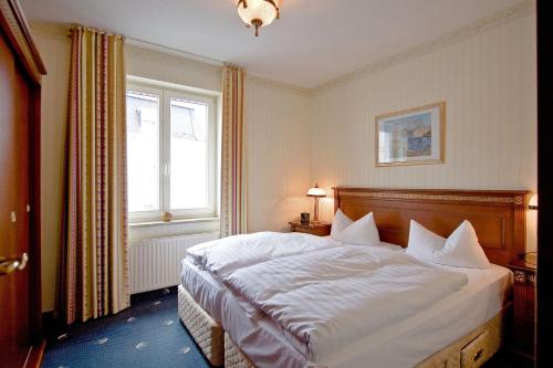 塞巴特阿尔贝克奥斯特西阿尔贝克西特尔酒店的一间卧室配有一张带白色床单的床和一扇窗户。