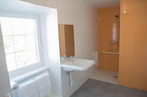 梅特泽拉黄金太阳酒店的一间带水槽、窗户和浴缸的浴室