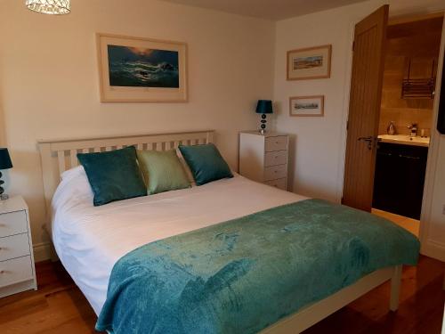 圣艾夫斯Primrose House的卧室配有带蓝色枕头的大型白色床
