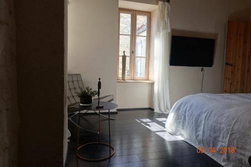 阿尔桑雷Les Clés d'Ars的一间卧室配有一张床、一张桌子和一个窗户。