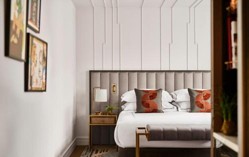 马德里Gran Hotel Inglés - The Leading Hotels of the World的一间卧室配有一张床和一张带台灯的桌子