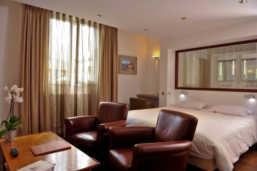 圣让皮耶德波尔比利牛斯酒店的酒店客房,配有一张床和两把椅子