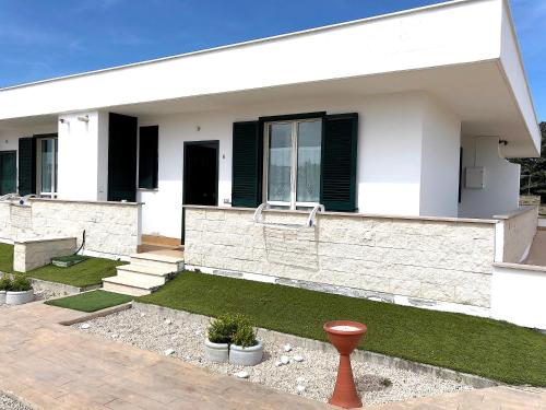 内图诺Residence Pegaso的白色的房子,有黑色的窗户和草地