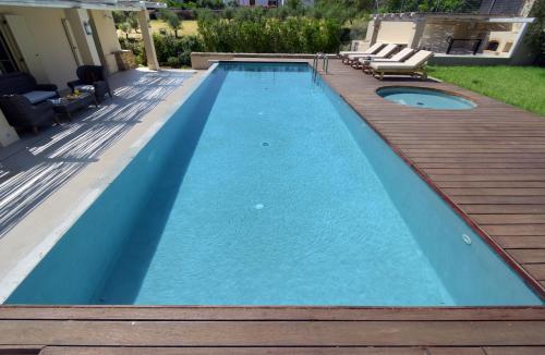 雅拉尼奥Geraniotis Villa的一个带木甲板和游泳池的游泳池