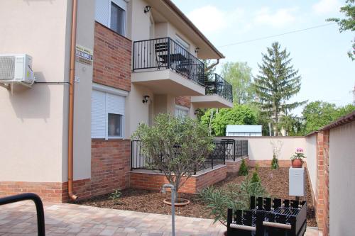 豪伊杜索博斯洛Imola és Andrea Apartmanház 2的公寓大楼设有阳台和2个长凳