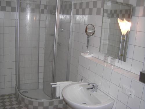 施特劳宾AKZENT Hotel Landgasthof Murrer的带淋浴、盥洗盆和镜子的浴室
