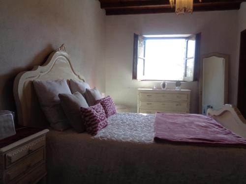 大佩德罗冈Sossego的卧室配有带枕头的床铺和窗户。