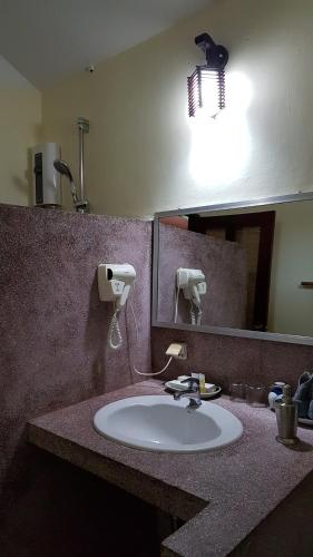 白马市米莉亚度假酒店的浴室设有水槽、镜子和灯