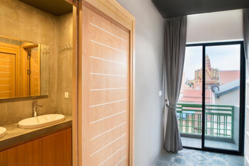 金边RS III地点旅馆的一间带水槽的浴室和一扇窗户的门