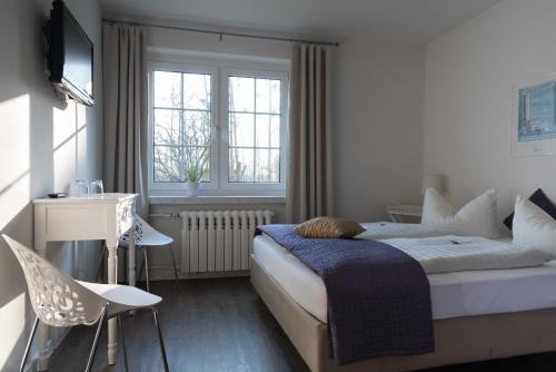 Sundhagen-NiederhofHaus ÜberLand的卧室配有一张床、一张书桌和窗户。