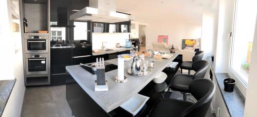 维尔茨堡Apartment Central Würzburg的厨房配有一张带黑色椅子的大桌子
