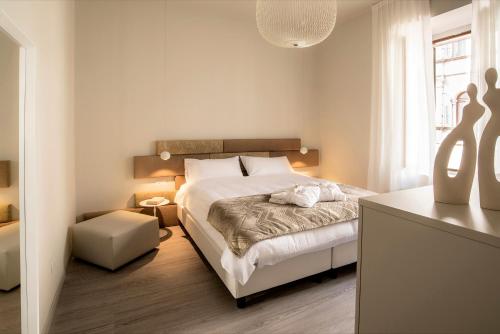 特伦托Cinquanta4 Charme Apartment的白色卧室配有床和桌子