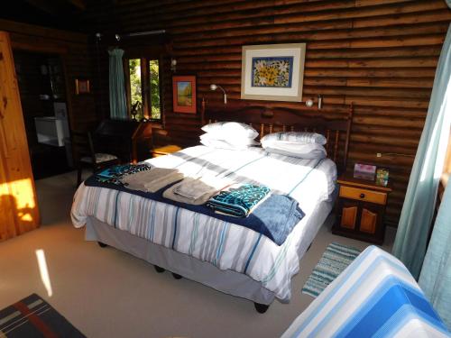 自然谷Forest Drive Holiday Home的小木屋内一间卧室,配有一张床