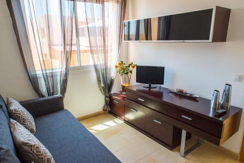科拉雷侯Apartment Delfines Sand Corralejo By Holidays Home的客厅配有沙发和书桌及电视