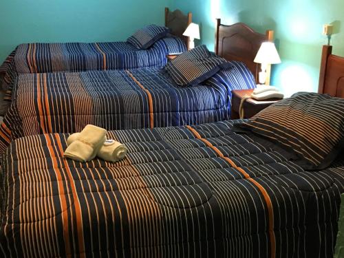 利纳雷斯Hotel Kolping San Ambrosio的两张位于酒店客房的床,配有毛巾