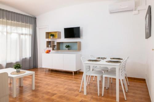 普拉加德阿罗RVHotels Apartamentos Benelux的客厅配有白色的桌子和椅子