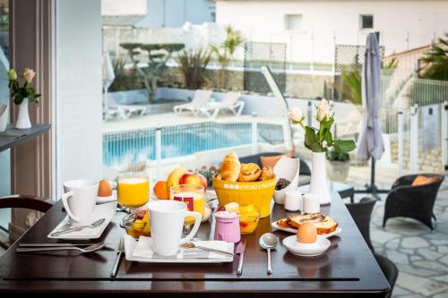 拉康提内勒法切欧克弗洛特酒店的阳台上的桌子上摆着早餐食品和饮料