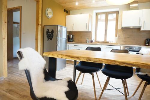 科巴里德ecoHouse FURLAN - Apartment PINJA的厨房配有桌子,椅子上坐着狗