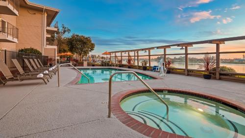奥克兰奥克兰行政酒店&套房的一座带椅子的度假村的游泳池和一座建筑