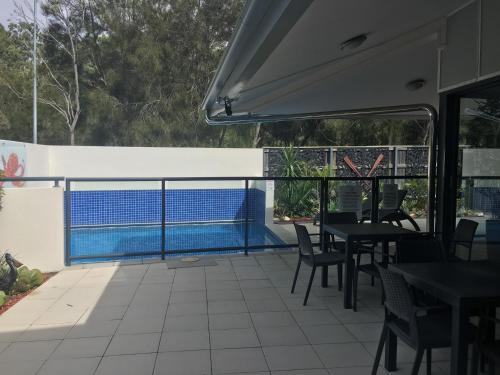 布里斯班曼利匡湖居汽车旅馆 的一个带桌椅的庭院和一个游泳池